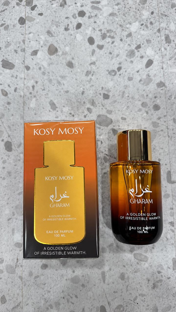 Gharam perfume in an amber and black bottle with gold coloured cap beside a gold and black box