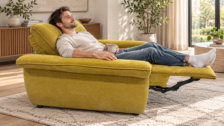 Man relaxing on extended mustard yellow electric recliner with long padded armrests